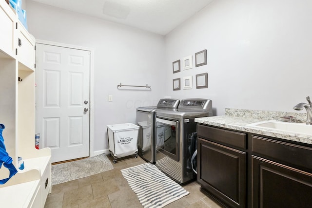 laundry area with cabinets, washing machine and clothes dryer, and sink