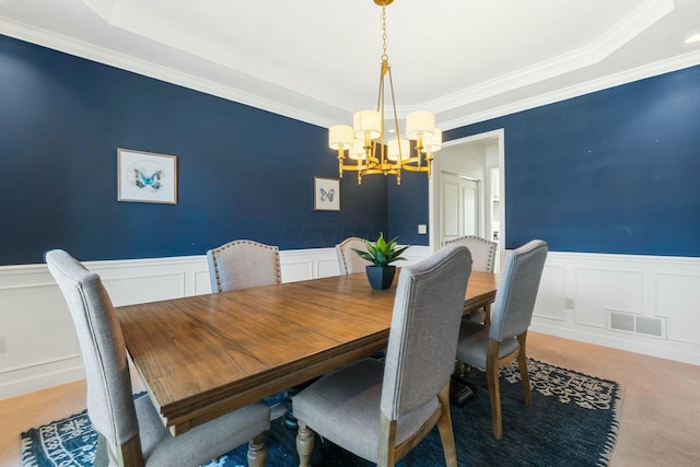 dining room featuring a tray ceiling, ornamental molding, a chandelier, and carpet flooring