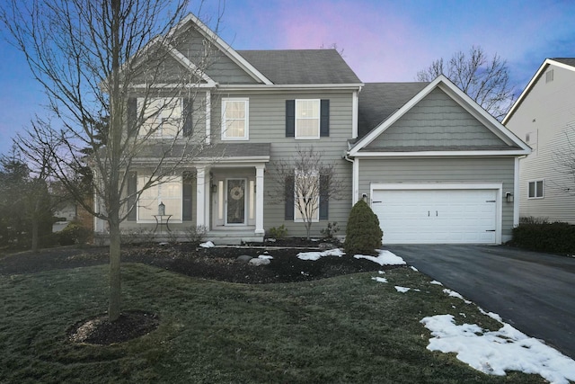 view of front of property with a yard and a garage