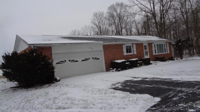 view of snowy exterior featuring a garage