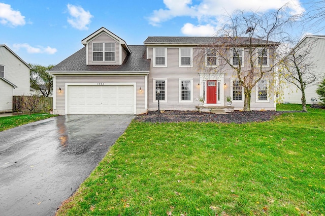 view of front of property with a front yard and a garage