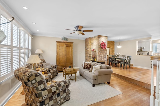 living room featuring light wood-type flooring, ceiling fan, and ornamental molding