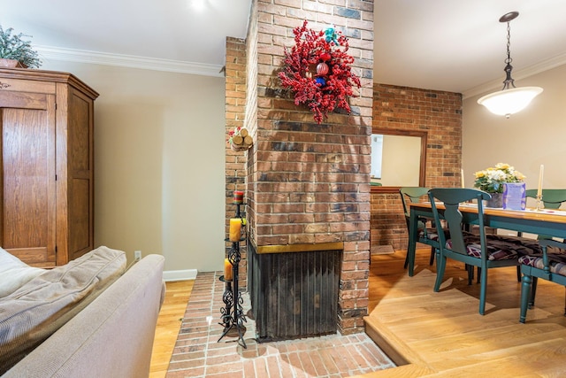 dining area with light wood-type flooring, ornamental molding, and a fireplace