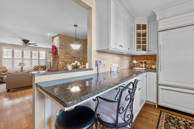 kitchen with ceiling fan, white cabinetry, kitchen peninsula, and light hardwood / wood-style flooring