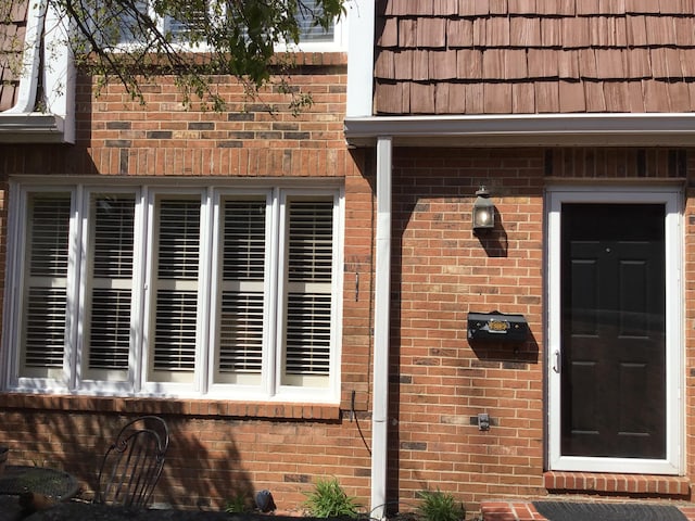 property entrance featuring brick siding