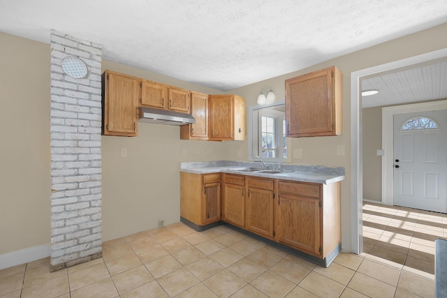 kitchen featuring a textured ceiling, light tile patterned floors, and sink