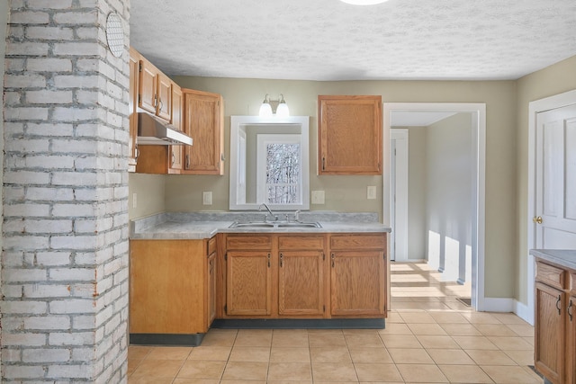 kitchen with light tile patterned flooring, a textured ceiling, and sink