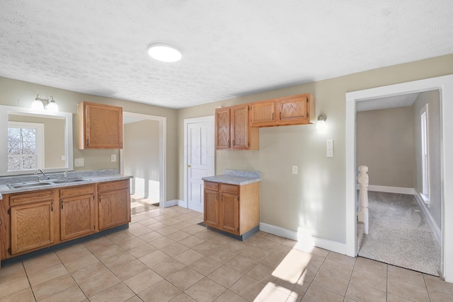 kitchen featuring sink, light tile patterned floors, and a textured ceiling