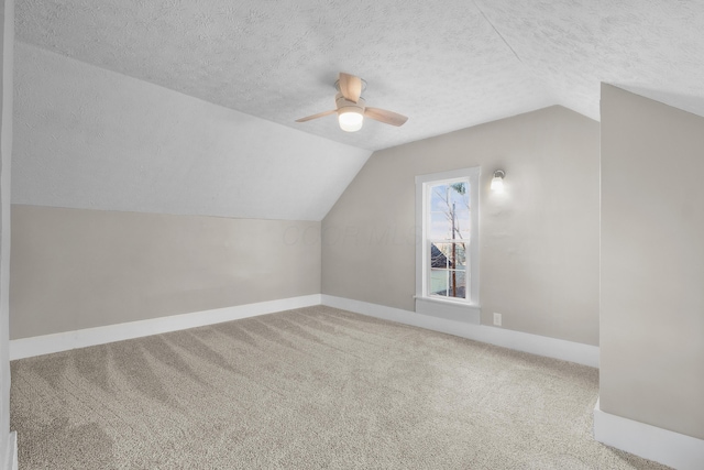 additional living space featuring a textured ceiling, vaulted ceiling, and ceiling fan