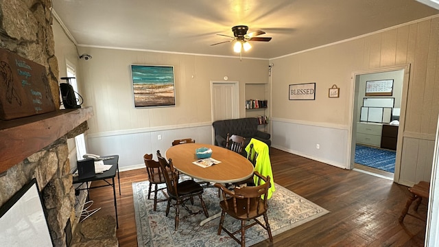 dining room with dark hardwood / wood-style flooring, crown molding, a fireplace, and ceiling fan