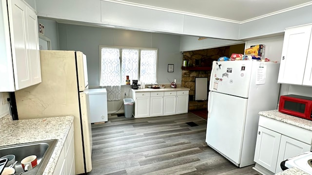 kitchen featuring dark wood-type flooring, white cabinets, crown molding, white fridge, and light stone counters