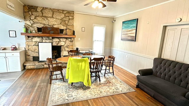 dining area with a fireplace, dark hardwood / wood-style floors, ceiling fan, and ornamental molding