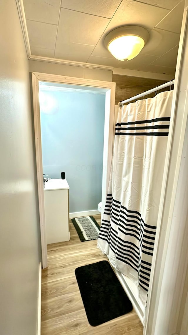 bathroom featuring hardwood / wood-style floors, crown molding, and walk in shower