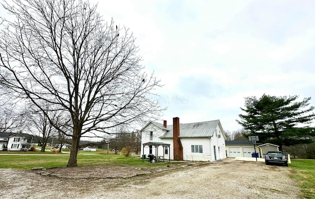 view of property exterior with a garage and a lawn