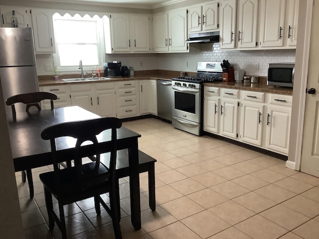 kitchen with sink, stainless steel appliances, light tile patterned floors, tasteful backsplash, and white cabinets