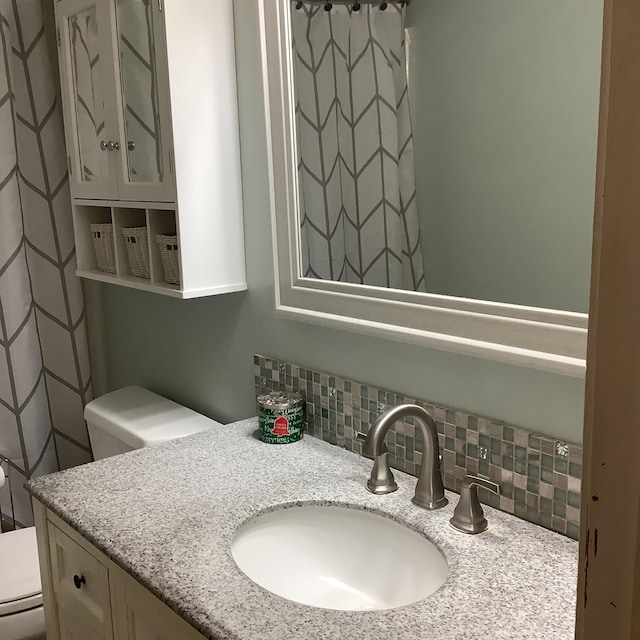 bathroom featuring decorative backsplash, vanity, and toilet