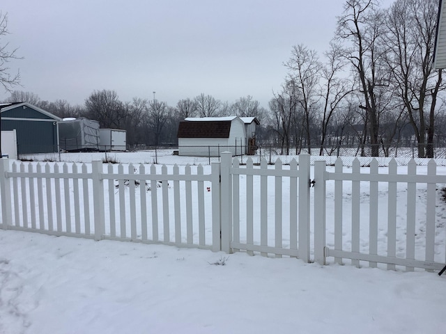 yard layered in snow with a storage shed