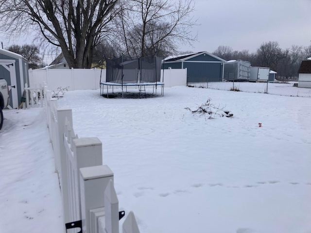 snowy yard featuring a trampoline