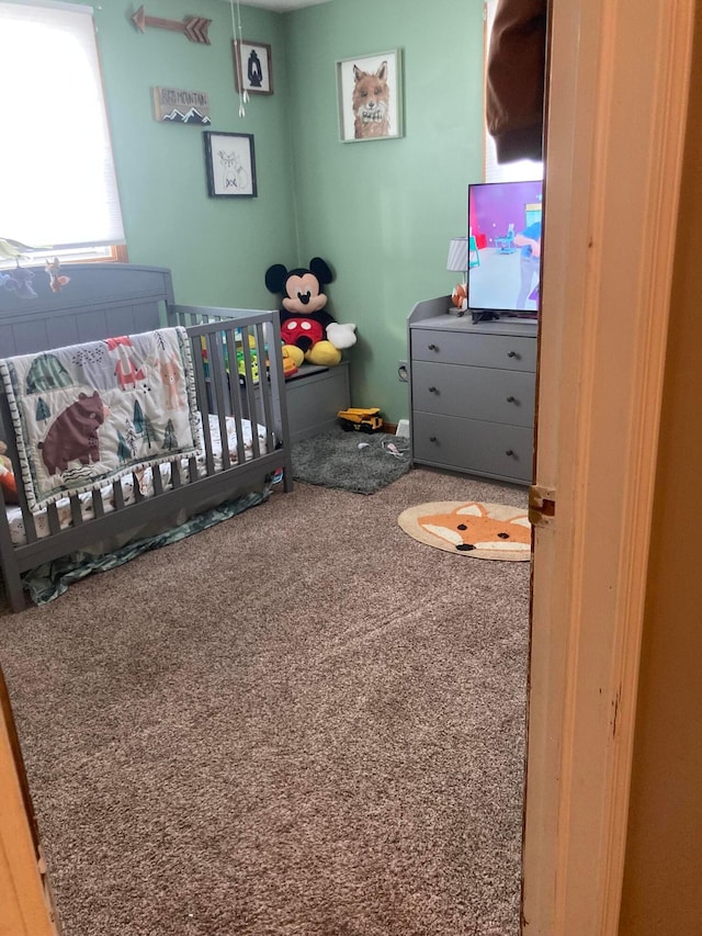 carpeted bedroom with a crib