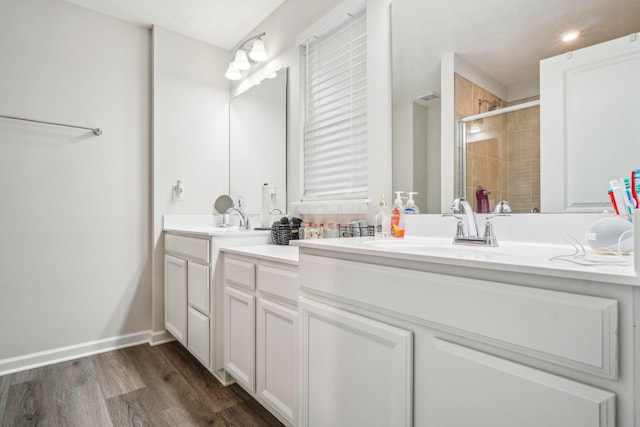 bathroom with hardwood / wood-style floors, vanity, and walk in shower