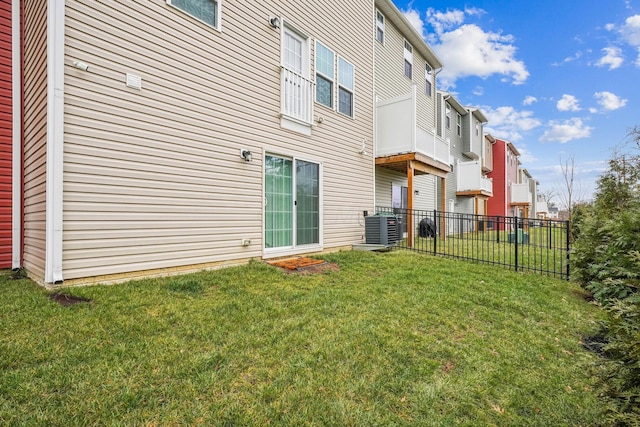 rear view of property featuring cooling unit and a lawn