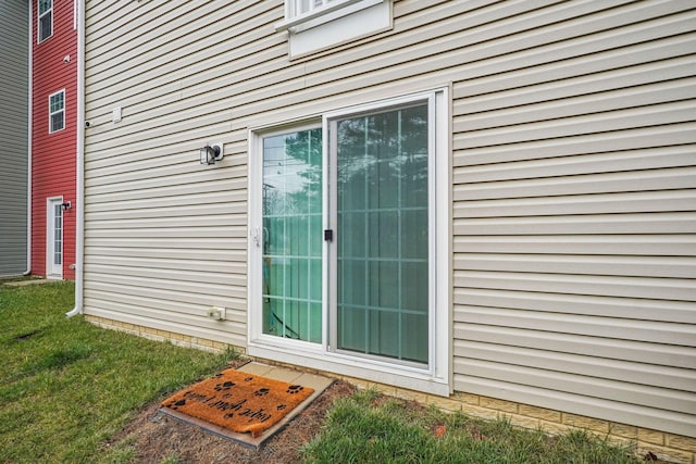 doorway to property with a lawn