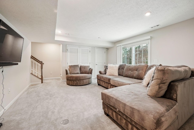 carpeted living room featuring a textured ceiling