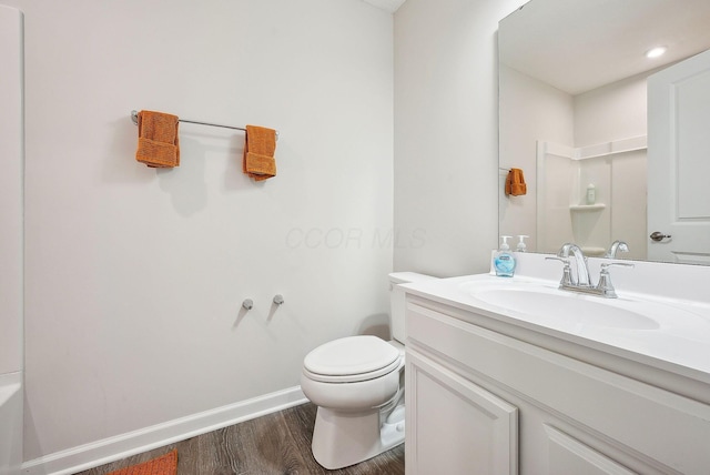 bathroom with walk in shower, hardwood / wood-style flooring, vanity, and toilet