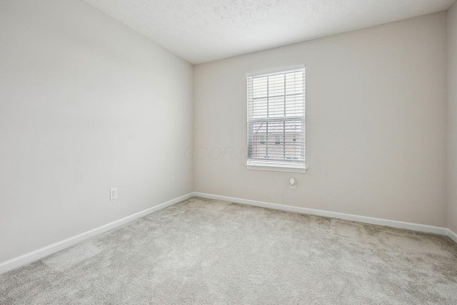 carpeted spare room with a textured ceiling