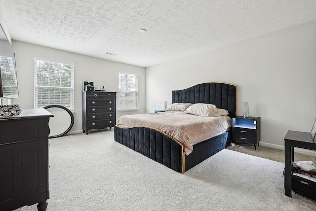 bedroom featuring a textured ceiling and light colored carpet