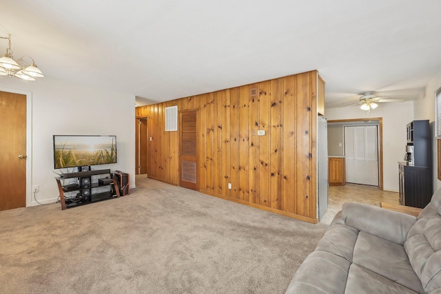 living room with light colored carpet, ceiling fan, and wooden walls