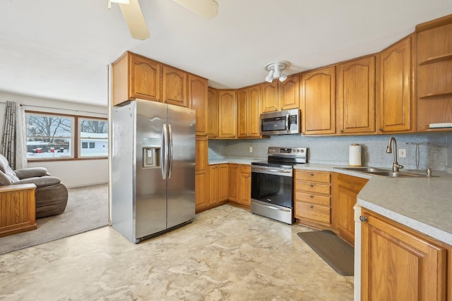 kitchen featuring decorative backsplash, ceiling fan, sink, and appliances with stainless steel finishes