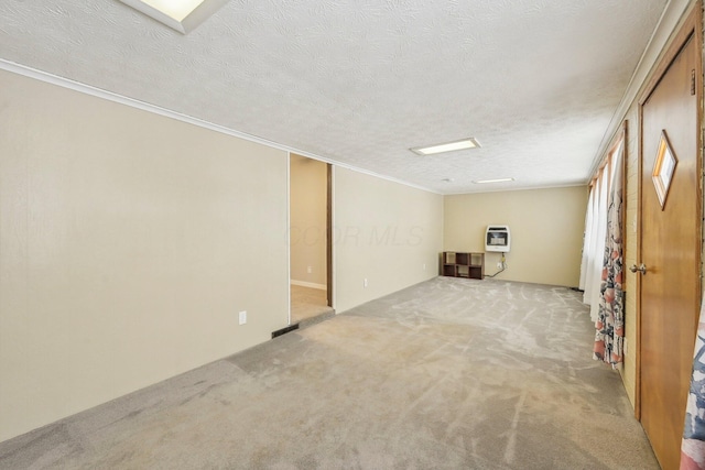 basement featuring a textured ceiling, heating unit, crown molding, and light colored carpet