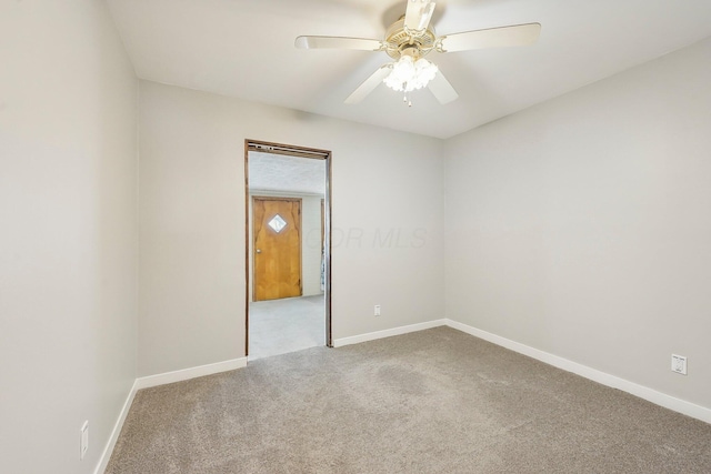 carpeted spare room featuring ceiling fan