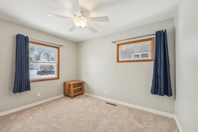 unfurnished room featuring light colored carpet and ceiling fan