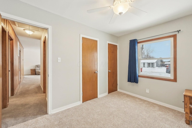 unfurnished bedroom featuring ceiling fan, a closet, and light colored carpet