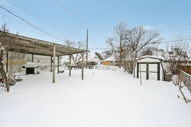 snowy yard featuring a shed