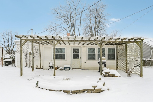 snow covered house featuring a pergola