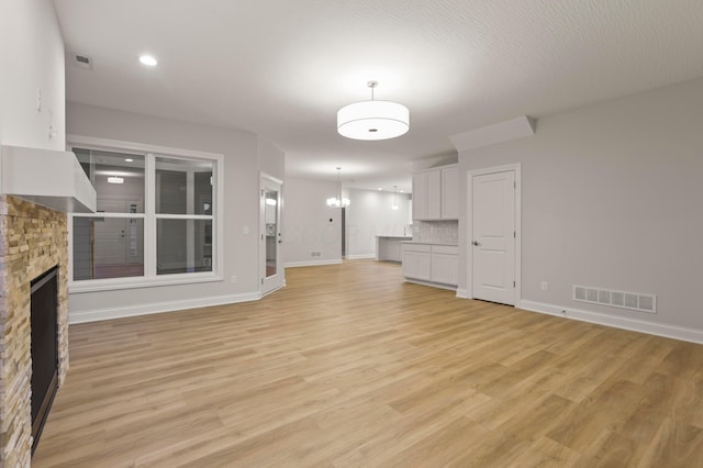 unfurnished living room featuring a fireplace and light hardwood / wood-style floors