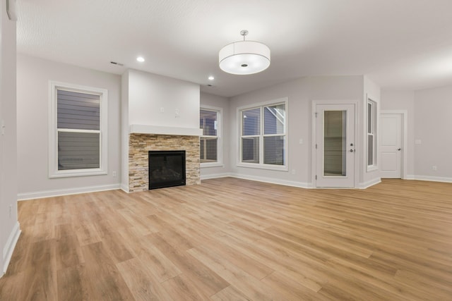 unfurnished living room featuring a fireplace and light hardwood / wood-style flooring