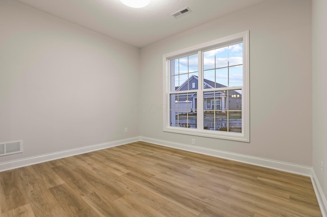 spare room with light hardwood / wood-style flooring and a textured ceiling