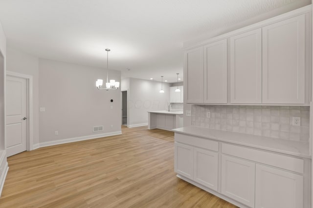 interior space featuring an inviting chandelier, light hardwood / wood-style flooring, and sink