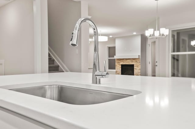 interior details featuring a fireplace, pendant lighting, an inviting chandelier, and sink