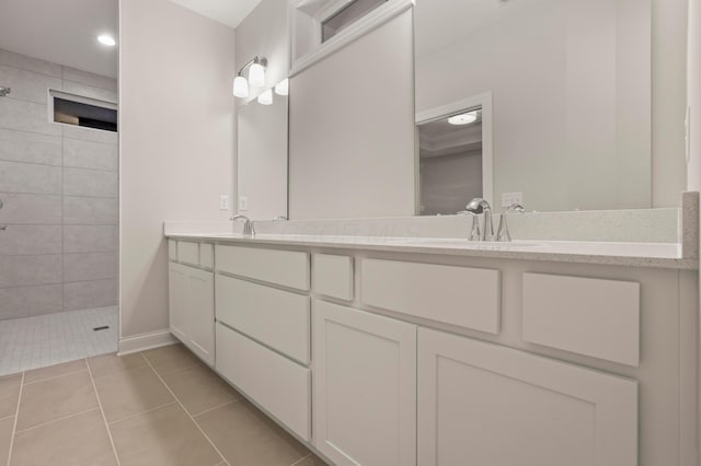 bathroom featuring tile patterned flooring, vanity, and tiled shower