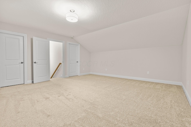 bonus room featuring light colored carpet and lofted ceiling