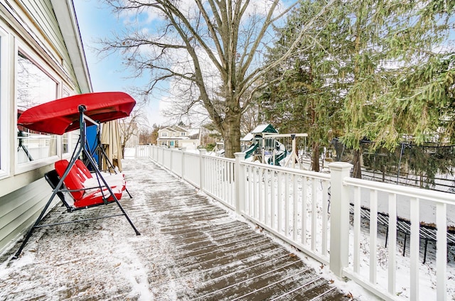 snow covered deck featuring a playground