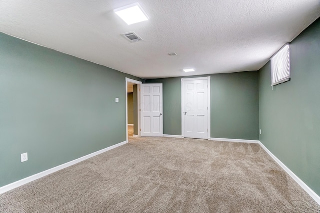 carpeted spare room with a textured ceiling