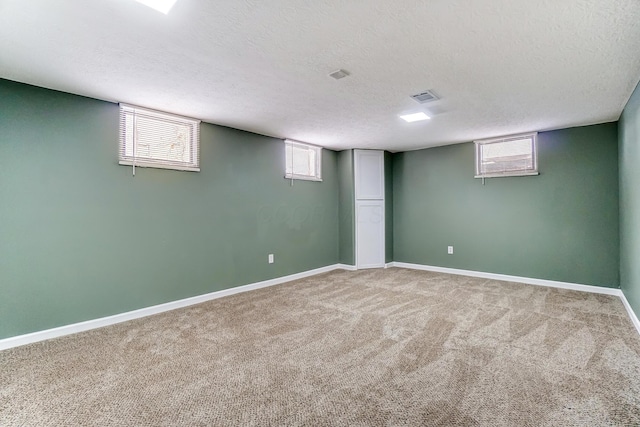 basement with carpet flooring and a textured ceiling