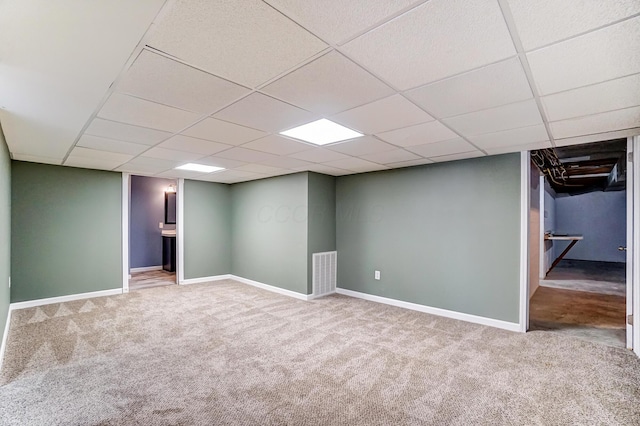 basement featuring carpet flooring and a paneled ceiling