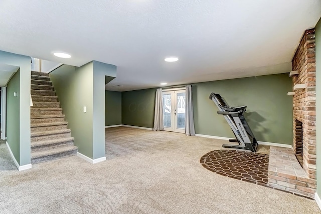 workout room featuring a fireplace, french doors, and carpet floors